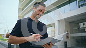 Focused director holding documents signing contract at office exterior closeup