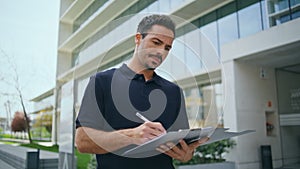 Focused director holding documents signing contract at office exterior closeup