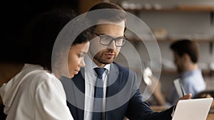 Focused diverse employees working on computer in office.