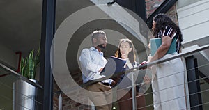 Focused diverse group of business people working together, discussing work in modern office