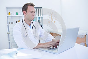 Focused doctor working with laptop