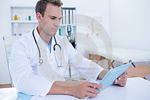 Focused doctor working with tablet computer