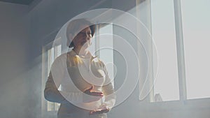 Focused elderly woman practicing tai chi gymnastic in gym