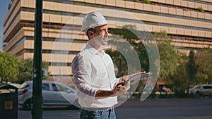 Focused engineer checking building plan at sunbeams city closeup. Man working