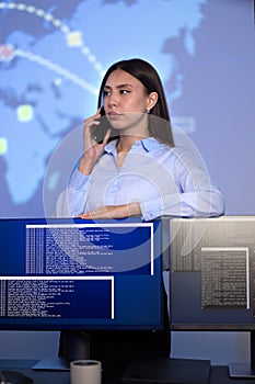 Focused Female Cybersecurity Manager talking in the phone in Enterprise Cyber Security Operations Center SOC