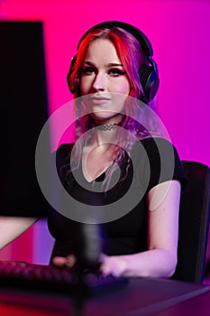 Focused Female Gamer Playing in Neon-Lit Room