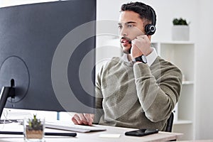 Focused on finding a solution. a handsome young male call center agent working in his office.