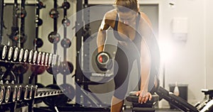 Focused fit woman training lats and lifting weights in fitness gym