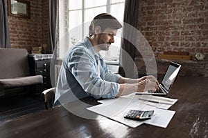 Focused freelance business man doing accounting job at home