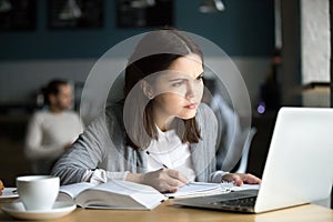 Focused girl concerned about difficult online task studying in c