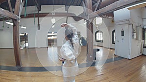 Focused girl demonstrating karate movements in practice room