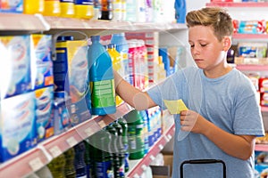 Focused glad boy looking at shopping list