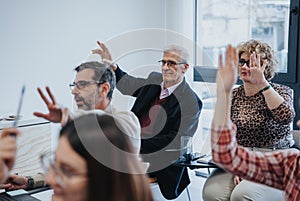 A focused group of employees actively participating in a workshop or business meeting by raising their hands to ask