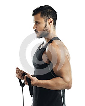 Focused on his workout. Studio shot of a young man working out with a resistance band against a white background.