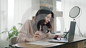 Focused hispanic marketing specialist working on laptop computer in home office