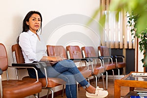 Focused hispanic woman jeans waiting for job interview in office