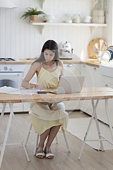 Focused homeowner girl doing domestic accounting work at home