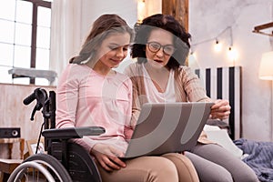 Focused immobile girl and woman surfing net