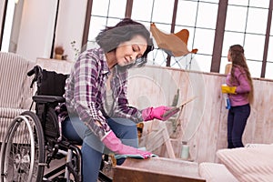 Focused immobile woman getting rid of dust