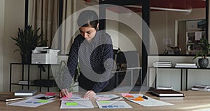 Focused indian employee working in office applying stickers on papers