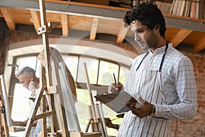 Focused inspired young student man engaged in creative class