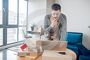 Focused Internet store employee staring at his laptop screen