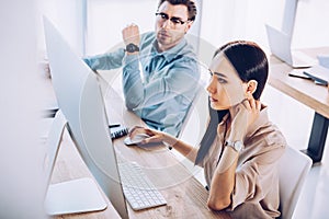 focused interracial business colleagues working on project together at workplace