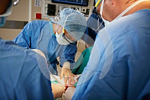 Focused on an intricate surgical procedure. a team of surgeons performing a surgery in an operating room.