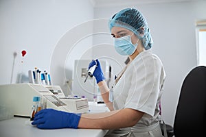 Focused lab technician preparing clinical specimens for a coagulation analysis