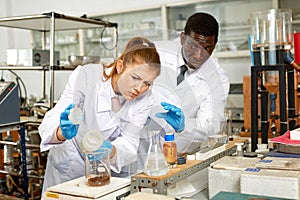 Focused lab technician woman with tubes and worried man technician
