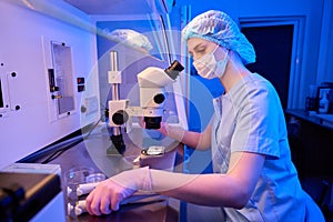 Focused laboratory scientist is preparing for cell manipulation procedure
