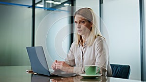 Focused lady sipping coffee modern cabinet closeup. Person taking office break