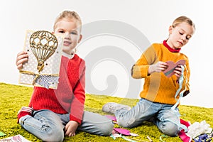 focused little sisters making diy greeting cards while sitting on floor