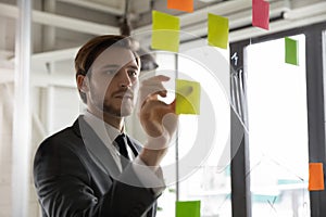 Focused male employee work with sticky notes develop business plan