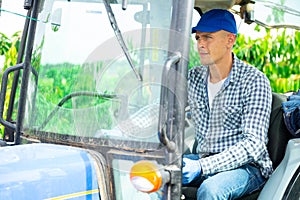 Focused male farmer sits at the wheel of an agricultural forklifttruck photo