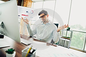 Focused male professional working in modern office environment with documents and computer for business project.