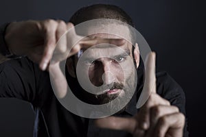 Focused man building frame with fingers. photo