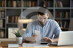 Focused man calculate household finances at home