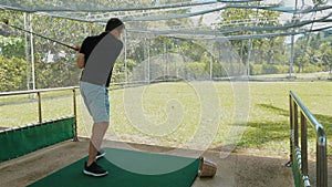 Focused man practicing golf swing on