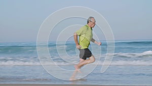 Focused man running at fast pace along ocean coast on summer day