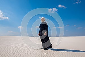 Focused man standing in the desert and meditates