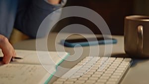 Focused man staring screen at night flat closeup. Guy hands typing keyboard