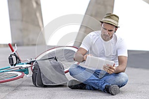 Focused man with tablet and bike