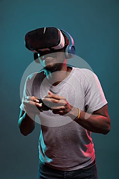 Focused man using controller and vr glasses to play futuristic game