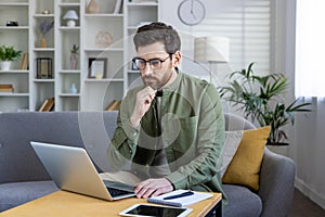 Focused man working remotely from a stylish home office