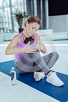 Focused mature woman having injury after workout