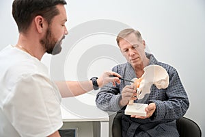 Focused middle-aged man having clinic appointment with orthopaedist