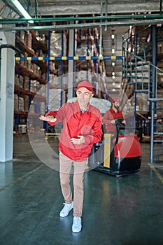Focused middle-aged supervisor working in the warehouse