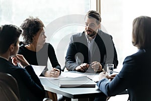 Focused mixed race employees listening to team leader.