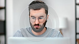 Focused modern man in eyeglasses browsing internet wireless connection web page use laptop pc